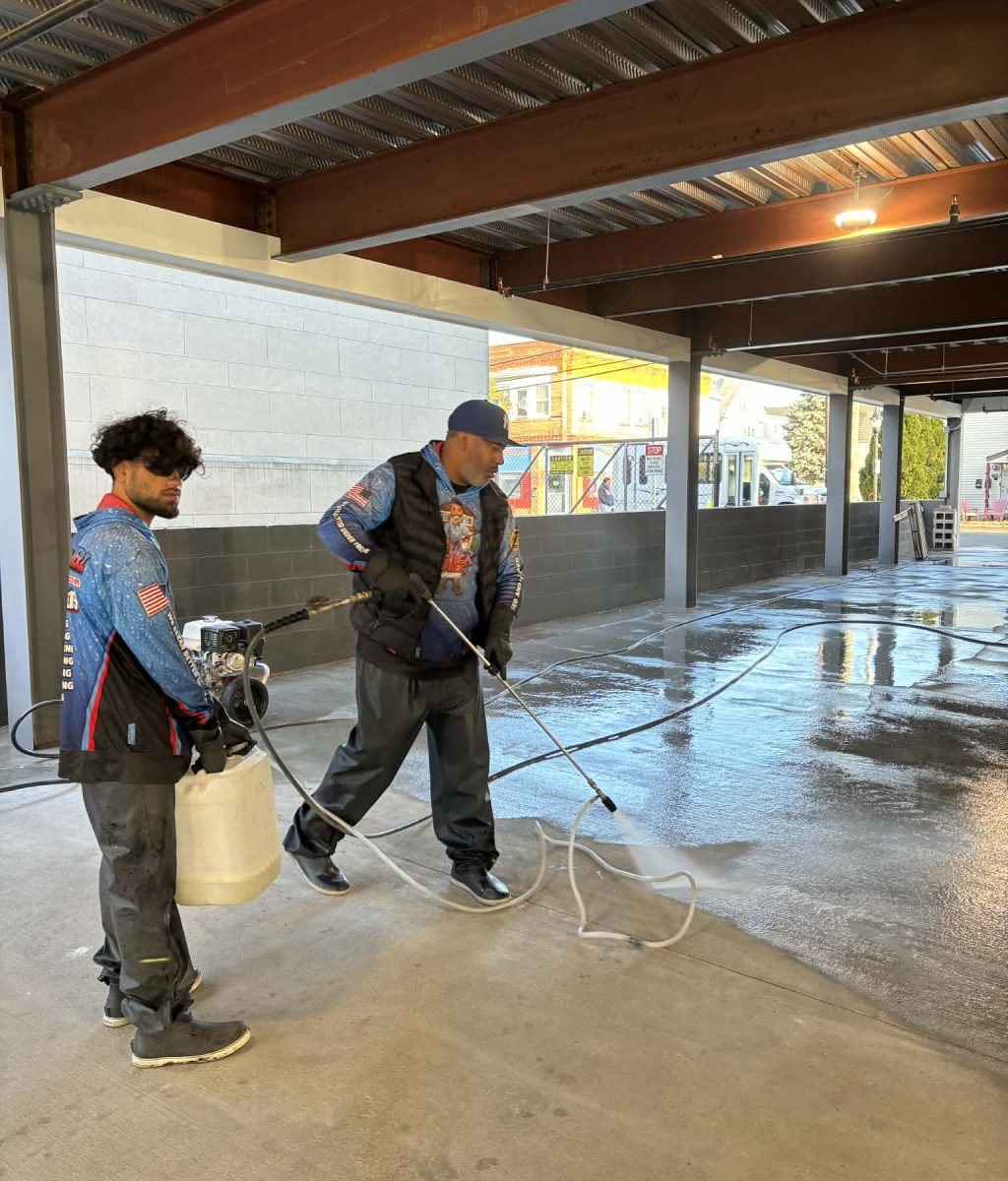 Crew cleaning a large concrete floor with professional equipment