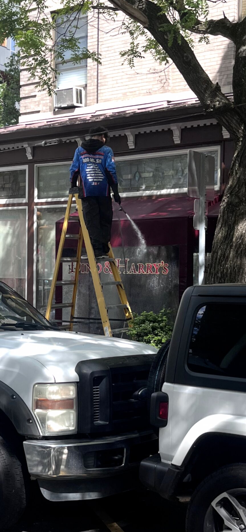 Crew member washing the awning at Dino and Harry's in Hoboken
