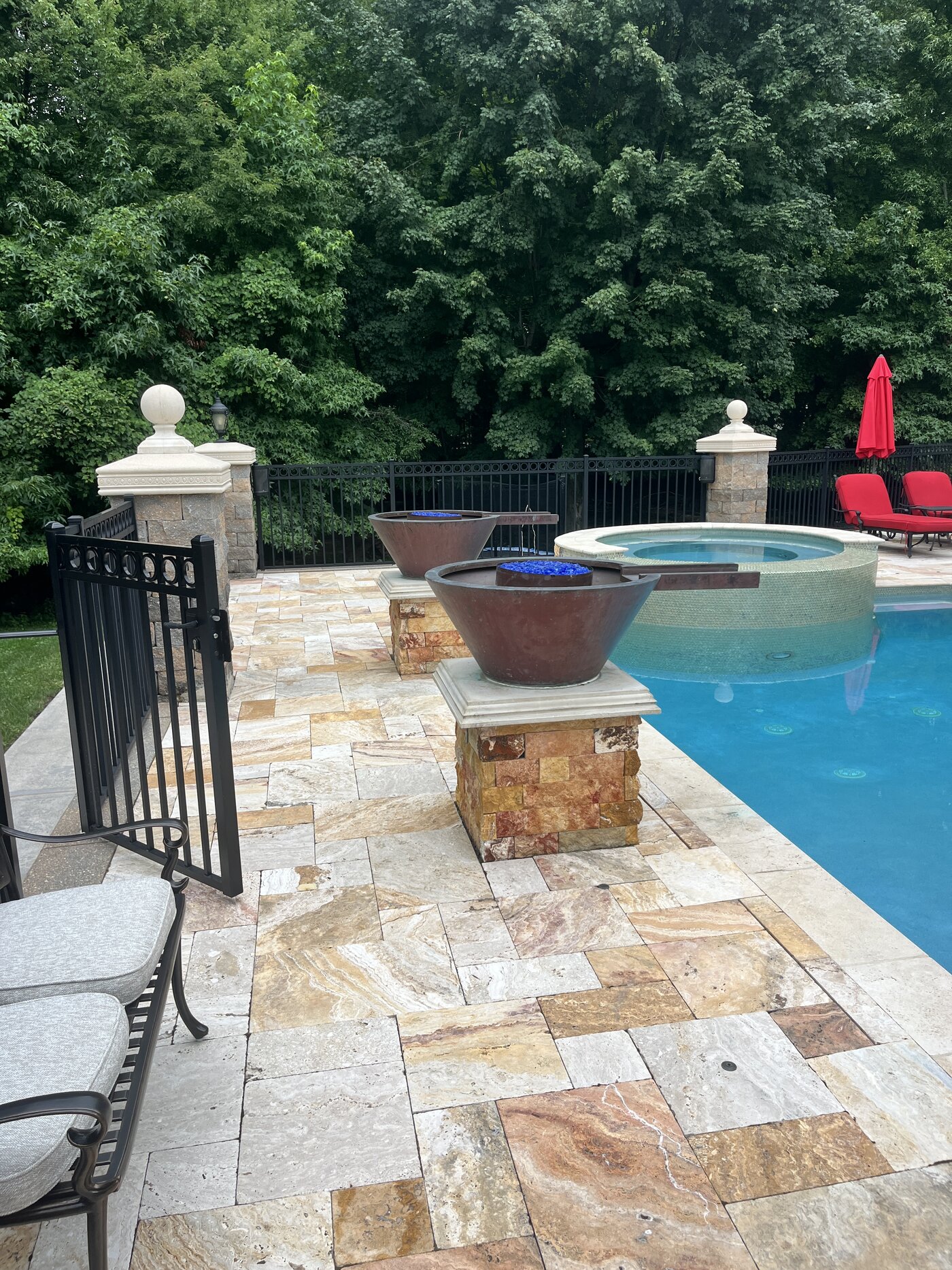 Clean travertine pool patio with fire bowls after washing