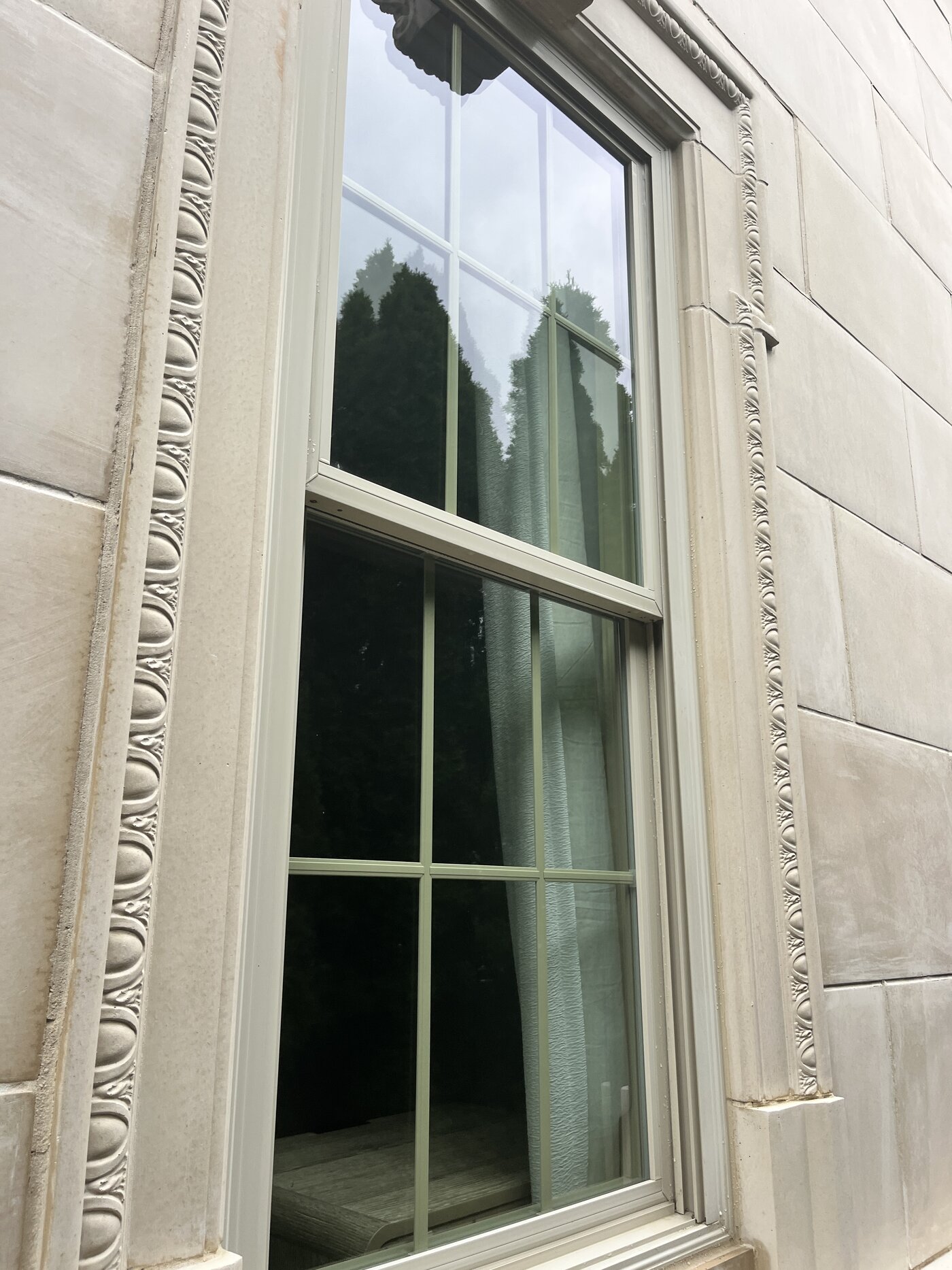 Crisp clean window set in carved limestone trim after cleaning