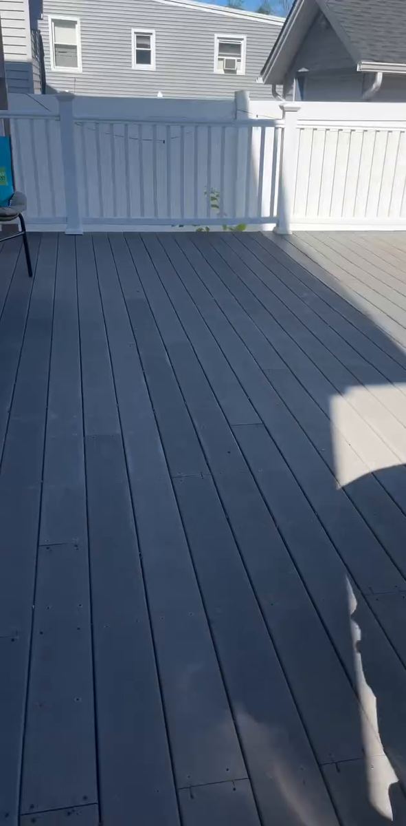 A clean composite deck with white railings drying in the afternoon sun
