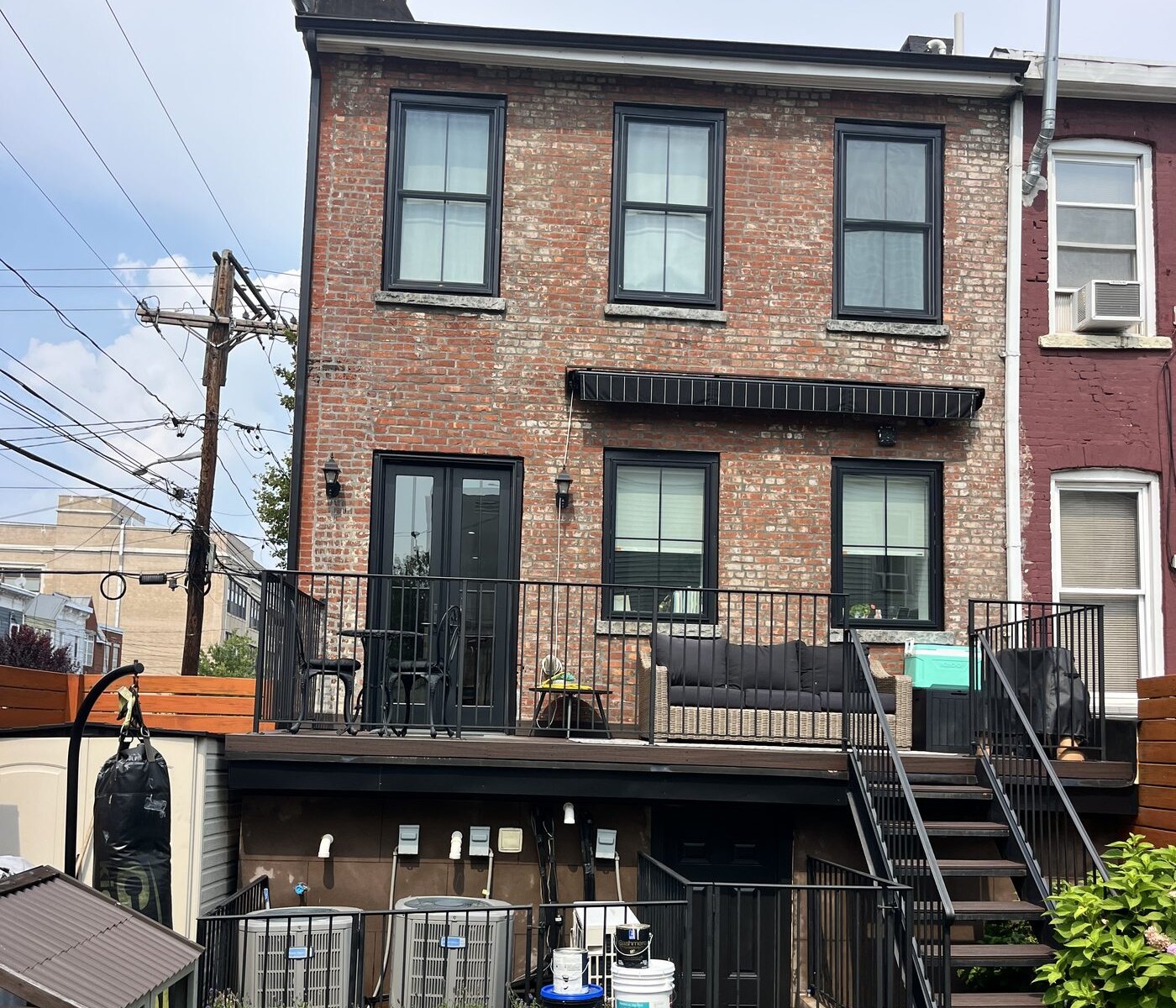 Restored brick rowhouse with black trim after exterior cleaning in Jersey City, NJ