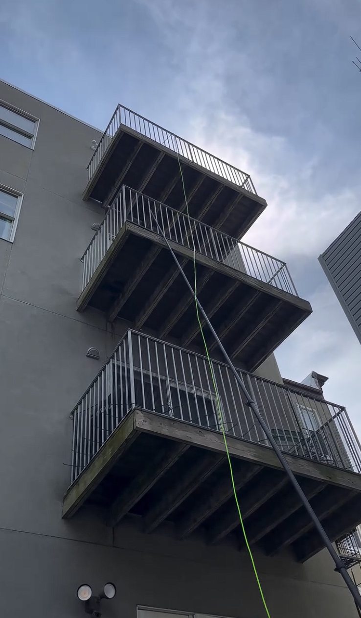 The rear elevation with stacked balconies and a water fed pole extended toward the upper windows