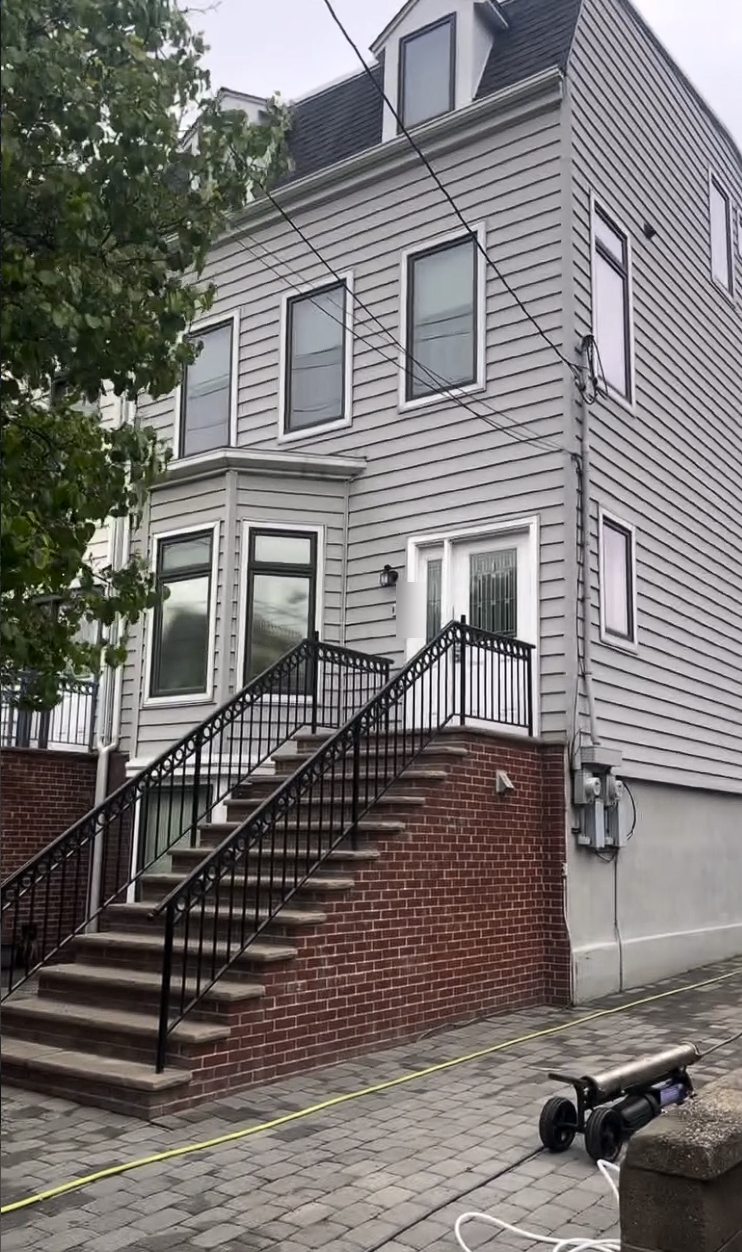A three story gray sided home in Jersey City Heights after a house wash and window cleaning