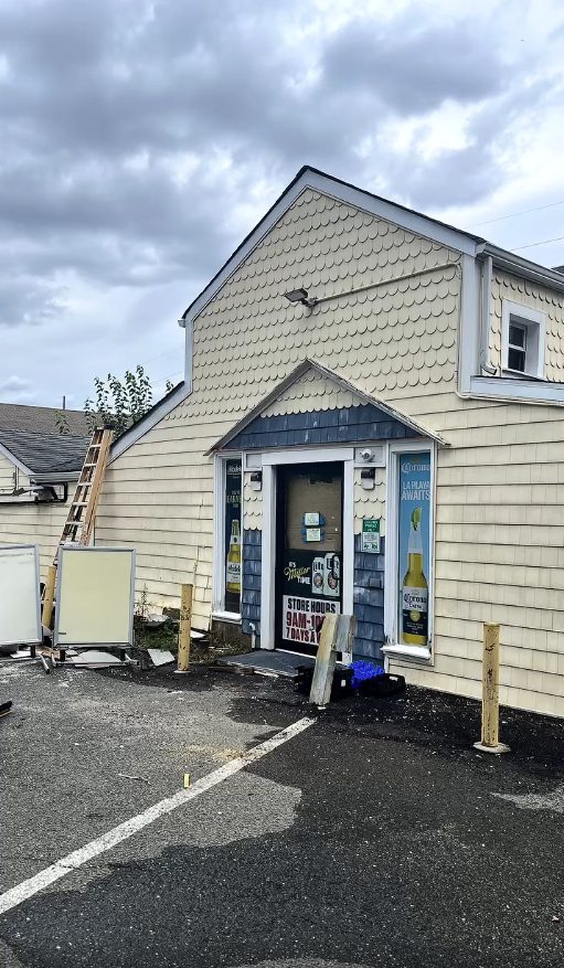 The front gable of the Matawan store during exterior cleaning with a ladder staged