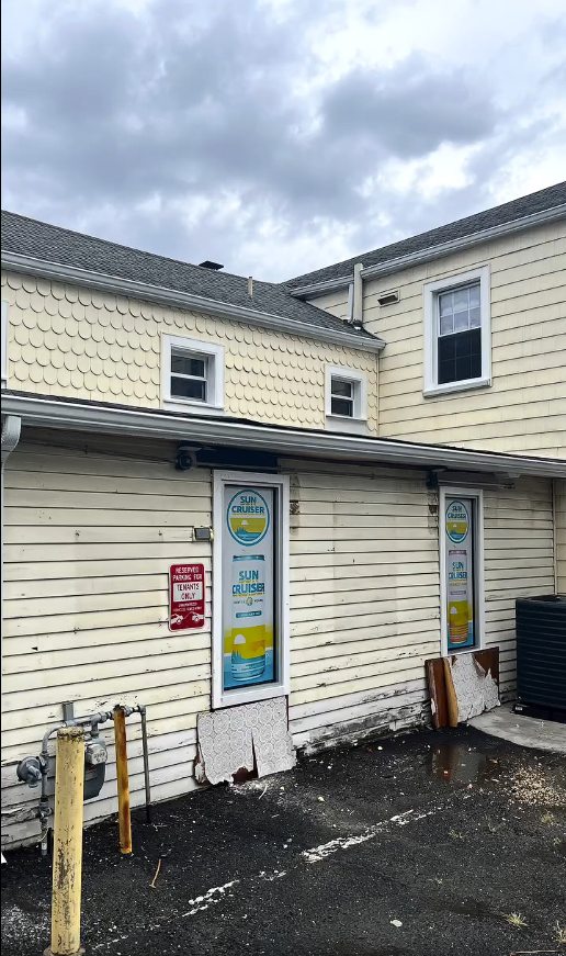 Weathered siding and staining on the rear elevation of the Matawan store