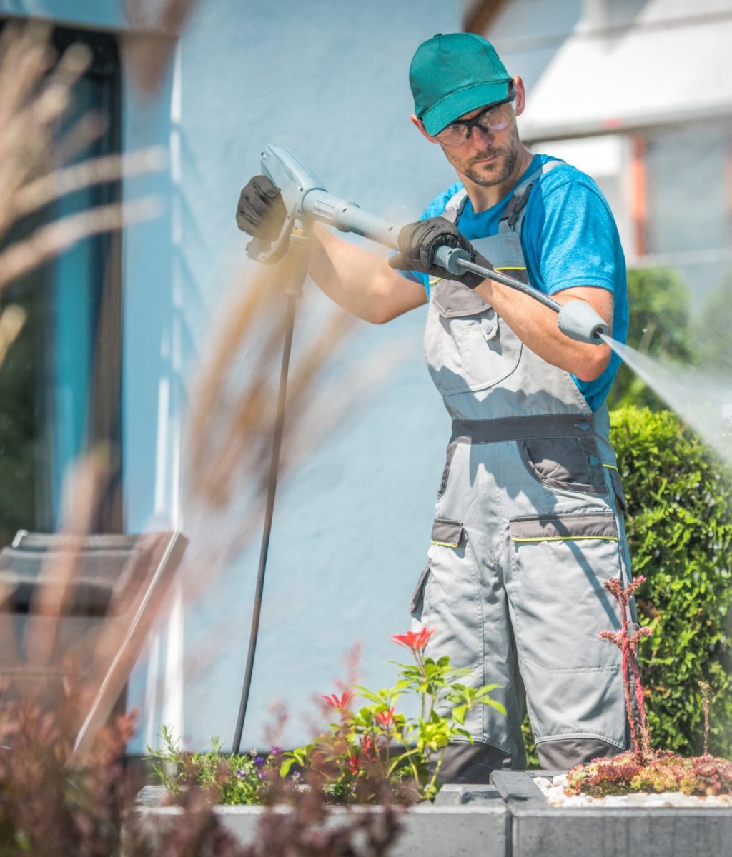 Pressure Washing in the Garden. Caucasian Men in His 30s and the Spring Cleaning.